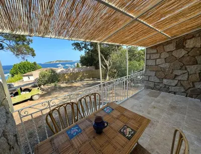a patio with a table and chairs on a balcony at Casa Amore Pinarello in Zonza