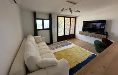 a living room with a white couch and a television at Casa Amore Pinarello in Zonza