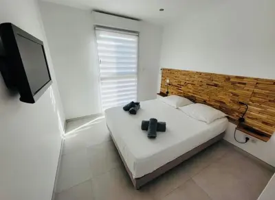 a bedroom with a bed and a flat screen tv at Villa Domaine U Murtonu in Porto-Vecchio