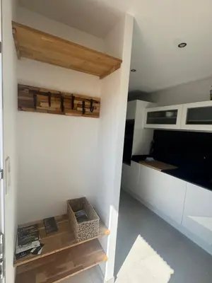 a kitchen with white walls and wooden shelves at Villa Domaine U Murtonu in Porto-Vecchio