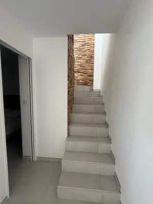 a stairway with white walls and a stair case at Villa Domaine U Murtonu in Porto-Vecchio