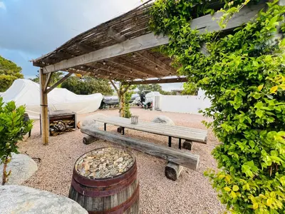 a wooden bench and a barrel and a tent at Villa Domaine U Murtonu in Porto-Vecchio