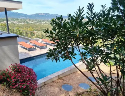 a swimming pool with a view of the mountains at Villa Pinarello vue panoramique mer piscine privée chauffée, plage à 900m in Zonza