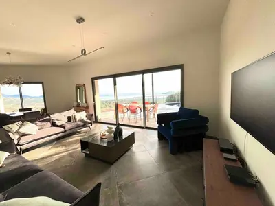 a living room with a large flat screen tv at Villa Pinarello vue panoramique mer piscine privée chauffée, plage à 900m in Zonza