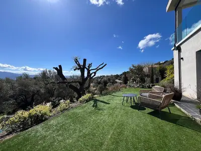 a yard with a couch and a table on the grass at Bas de villa aux portes d'Ajaccio in Alata