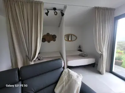 a living room with a couch and a window at Bas de villa aux portes d'Ajaccio in Alata