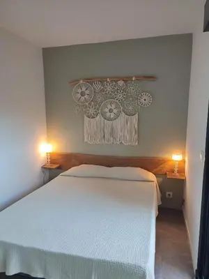 a bedroom with a white bed and two lamps at Charmante maisonette in Porto-Vecchio