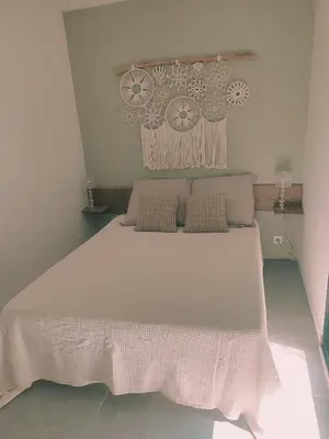 a bedroom with a large white bed with pillows at Charmante maisonette in Porto-Vecchio
