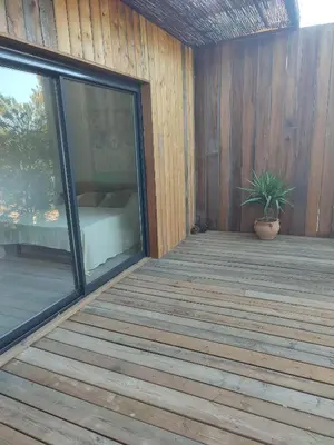a wooden deck with a potted plant on it at Charmante maisonette in Porto-Vecchio