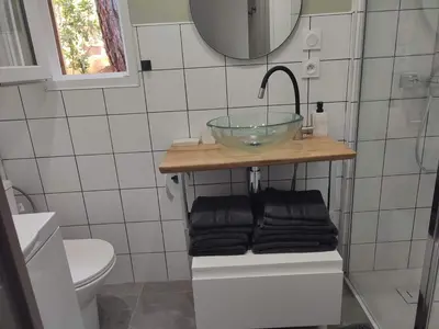 a bathroom with a bowl sink and towels at Charmante maisonette in Porto-Vecchio