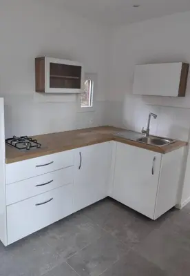 a kitchen with white cabinets and a sink at Charmante maisonette in Porto-Vecchio