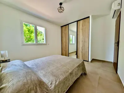 a bedroom with a large bed and two windows at Villa Antonia in SERRA DI FIUMORBO
