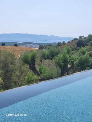 a swimming pool with a view of a field and trees at Haut de villa aux portes d'Ajaccio in Alata