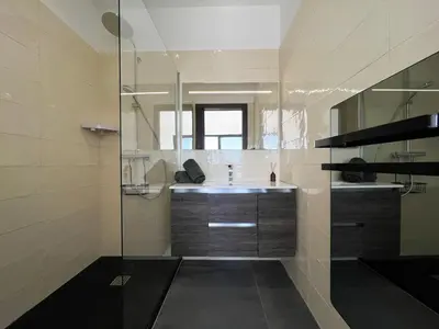 a bathroom with a sink and a glass shower at Haut de villa aux portes d'Ajaccio in Alata