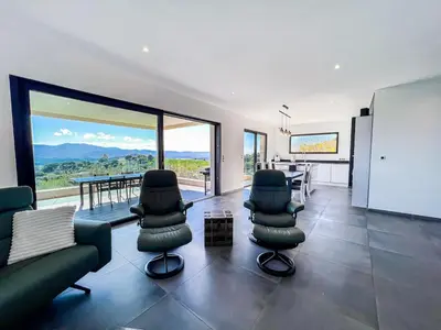 a living room with a couch and chairs and a table at Haut de villa aux portes d'Ajaccio in Alata
