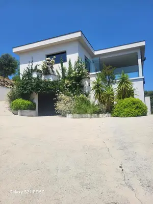 a white house with plants in front of it at Haut de villa aux portes d'Ajaccio in Alata