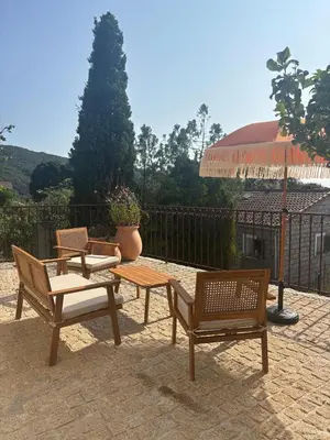 a patio with three chairs and a table and an umbrella at Casa Pitrina in Viggianello