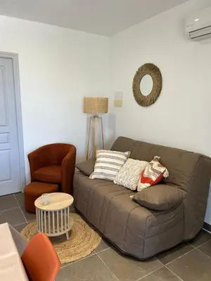a living room with a couch and a chair at Villa Roccapina - Porto-Vecchio in Sotta