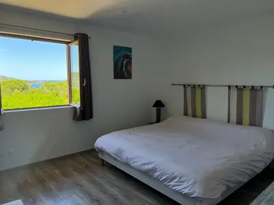 a bedroom with a bed and a large window at Costa di fiori in Coti-Chiavari