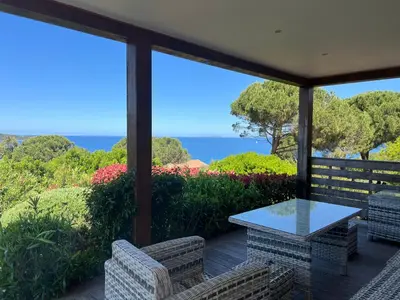 a patio with a table and chairs and the ocean at Costa di fiori in Coti-Chiavari