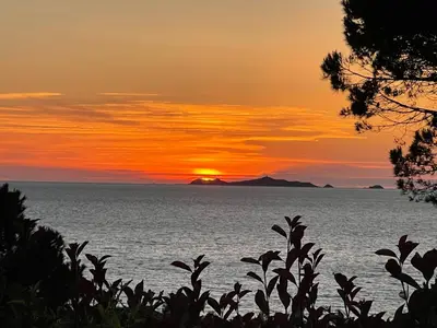 a sunset over the ocean with a mountain in the background at Costa di fiori in Coti-Chiavari