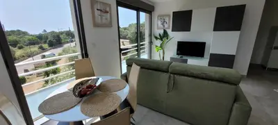 a living room with a couch and a table at Dormir à Pinarello Corse du Sud 4 pers Vue Mer in Sainte-Lucie de Porto-Vecchio