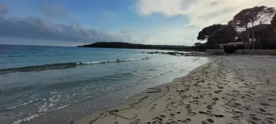 a beach with the ocean on a cloudy day at Dormir à Pinarello Corse du Sud 4 pers Vue Mer in Sainte-Lucie de Porto-Vecchio