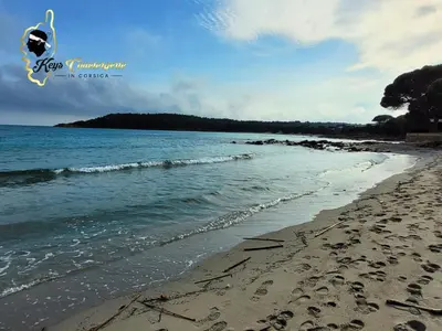 a beach with footprints in the sand and the ocean at Dormir à Pinarello Corse du Sud 4 pers Vue Mer in Sainte-Lucie de Porto-Vecchio