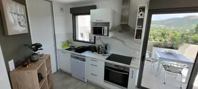 a small kitchen with white cabinets and a window at Dormir à Pinarello Corse du Sud 4 pers Vue Mer in Sainte-Lucie de Porto-Vecchio