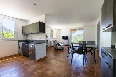 a kitchen and dining room with a table and a dining room at U Tadu - Maison de vacances en pierre avec vue et nature en Corse du Sud in Monacia-dʼAullène