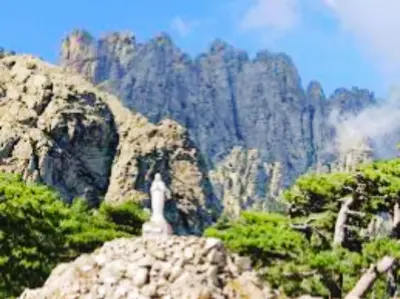 a statue sitting on top of a rocky mountain at Très joli gîte T3, 55m2 climatisé région Propriano 5 personnes in Compoli