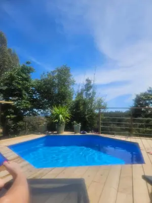 a blue swimming pool in a yard with trees at Maison au coeur du maquis in Porto-Vecchio