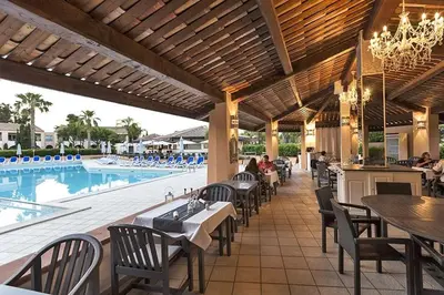 a restaurant with tables and chairs and a swimming pool at Cozy 2-room beachfront Résidence Sognu Di Mare Casa Serenita in Linguizzetta