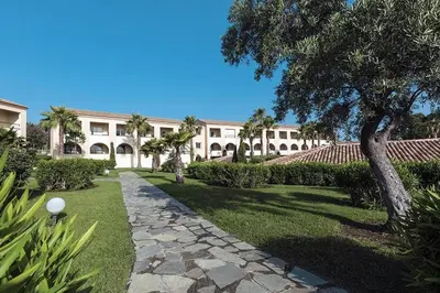 a building with a walkway in front of a yard at Cozy 2-room beachfront Résidence Sognu Di Mare Casa Serenita in Linguizzetta