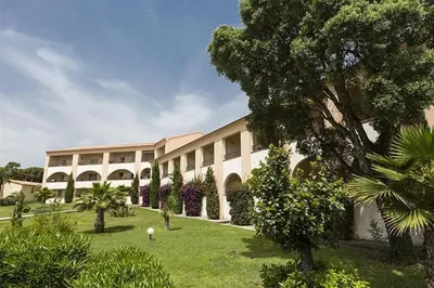 a building with trees and bushes in front of it at Cozy 2-room beachfront Résidence Sognu Di Mare Casa Serenita in Linguizzetta