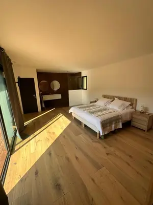 a bedroom with a bed and a wooden floor at Les chambres Toussaint in Pianottoli-Caldarello