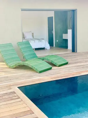 a bedroom with a bed and a swimming pool at Les chambres Toussaint in Pianottoli-Caldarello