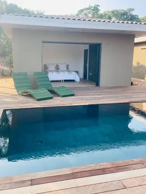 a bedroom with a bed and a swimming pool at Les chambres Toussaint in Pianottoli-Caldarello