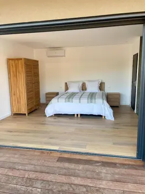 a bedroom with a bed and a wooden floor at Les chambres Toussaint in Pianottoli-Caldarello