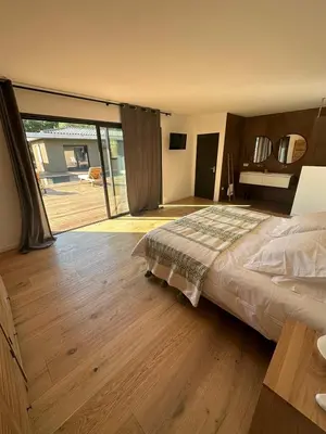 a bedroom with a large bed and a wooden floor at Les chambres Toussaint in Pianottoli-Caldarello