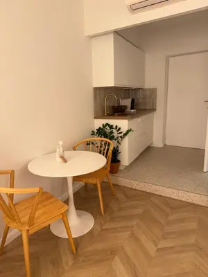 a room with a table and chairs and a kitchen at Appartement Ajaccio Casa Dea in Ajaccio