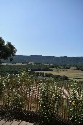a fence with a view of a field behind it at Amandula Bergerie Sotta hyper cozy in Sotta