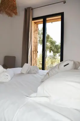 a bedroom with two white beds and a window at Amandula Bergerie Sotta hyper cozy in Sotta
