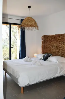 a bed with white sheets and pillows in a room at Amandula Bergerie Sotta hyper cozy in Sotta