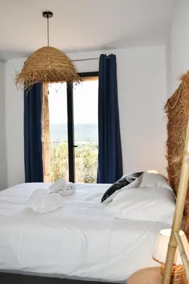 a bedroom with a bed with a large window at Amandula Bergerie Sotta hyper cozy in Sotta