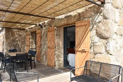 a wooden deck with a table and chairs on it at Amandula Bergerie Sotta hyper cozy in Sotta