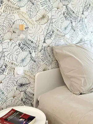 a bedroom with a bed with a floral wallpaper at CASA ANPÀ Maison Vue Mer in Lecci