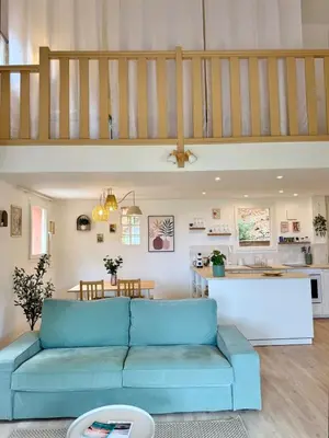 a living room with a blue couch and a kitchen at CASA ANPÀ Maison Vue Mer in Lecci