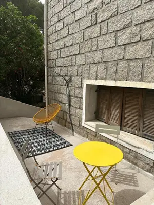 a yellow table and chairs next to a brick wall at Beau Studio au pied de la Cidatelle in Porto-Vecchio