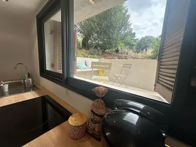 a kitchen with a window with a view of a patio at Beau Studio au pied de la Cidatelle in Porto-Vecchio
